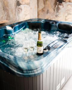 Una botella de champán y dos copas de vino en una bañera. en Etoiles de Provence BIEN-ETRE, en La Ciotat