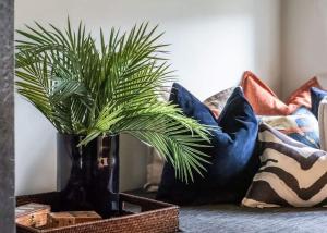 卑尔根Vertshuset Konow的沙发上放着几个靠枕，黑色花瓶里插着一盆植物。 更多27张照片