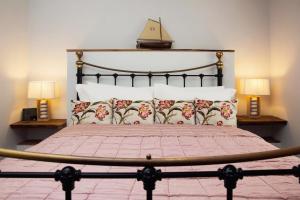 1 dormitorio con 1 cama grande y 2 lámparas en The Burrow at Burrow Wood Farm, en Ottery St Mary