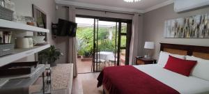 - une chambre avec un lit et une porte coulissante en verre dans l'établissement Mountain Gem, à Bloemfontein