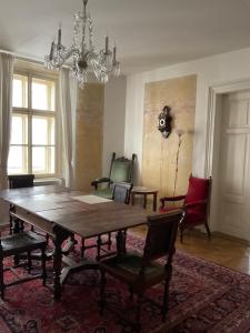 comedor con mesa, sillas y lámpara de araña en Luxury old Town Apartment, en Praga