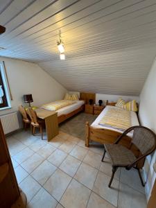 a attic room with two beds and a table and chairs at Ferienwohnung Gisela Schmidt in Amorbach