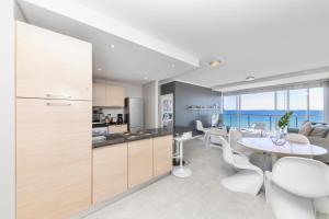 a kitchen and dining room with a table and chairs at Horizon Bay 702 in Bloubergstrand