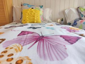 ein Bett mit rosa und lila Blumen drauf in der Unterkunft ALOJAMIENTO MIRABUENOS in Aranda de Duero