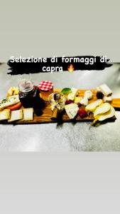 une planche à découper avec du fromage et d'autres denrées alimentaires. dans l'établissement Agriturismo La Betulla, à Brezzo