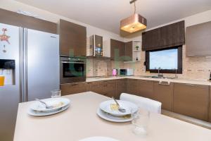 a kitchen with a white table and a refrigerator at ''Villa Elia'' in Dhíkella