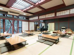 uma grande sala com mesas, cadeiras e janelas em Lupo Forest "GRAN FOREST Echizen Miyama" - Vacation STAY 06371v em Fukui