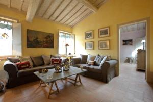a living room with two couches and a table at Podere La Strega in Siena