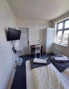 een kamer met een bed en een tv aan de muur bij Hotel Crone in Grenå