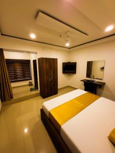 a bedroom with a large bed and a television at Thejaswini Residency Cheruvathur in Nīleshwar