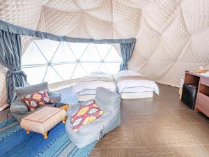 una habitación con 2 camas y un sofá en una tienda de campaña en Lupo Forest "GRAN FOREST Echizen Miyama" - Vacation STAY 07137v en Fukui