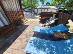 a patio with a table and a bench and an umbrella at Holiday Park Lu-Ka in Pakoštane