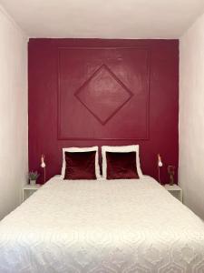 ein Schlafzimmer mit einem weißen Bett mit einer roten Wand in der Unterkunft Aurore - Château de Versailles - Central in Versailles