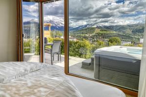een slaapkamer met uitzicht op een bad en de bergen bij Chalet Schlossberg Latemar in Nova Ponente