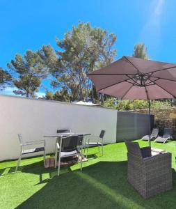 un patio con mesa, sombrilla y sillas en Etoiles de Provence BIEN-ETRE, en La Ciotat