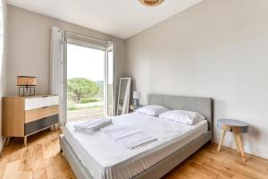 - une chambre blanche avec un lit et une fenêtre dans l'établissement Le Soleil du Lac/Terrasse/Parking/Clim, à Carcassonne