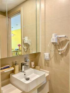 a bathroom with a white sink and a mirror at Mochi House - Căn hộ The Sóng in Vung Tau