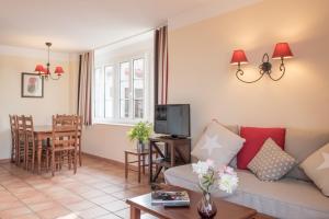 ein Wohnzimmer mit einem Sofa und einem Tisch in der Unterkunft Résidence Pierre & Vacances La Villa Maldagora in Ciboure