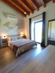 um quarto com uma cama grande e uma janela grande em Agriturismo Casale Lisalola em Sutri