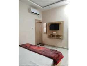 a room with a bed with a red blanket at The Ramagya Hotel, Chitrakoot in Sītāpur Mūāfi