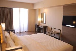 ein Hotelzimmer mit einem Bett und einem Schreibtisch in der Unterkunft The Aurora Subic Hotel Managed By HII in Olongapo