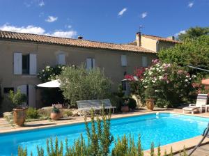 a villa with a swimming pool in front of a house at Domaine Lafayette in Loriol-du-Comtat
