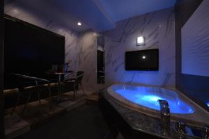 a room with a tub with a bar and a tv at Hotel Star Resort Hers (Adult Only) in Sagamihara