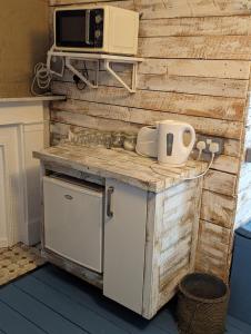 une cuisine avec un comptoir et un four micro-ondes sur un mur dans l'établissement Bunkhouse Bournemouth, à Bournemouth