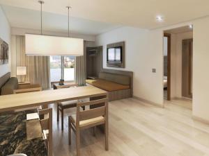 Cabot Tres Torres Apartamentos في بلايا ذي بالما: غرفة معيشة مع طاولة طعام وأريكة