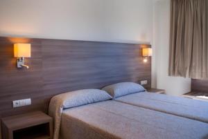 una camera con un letto e due luci sul muro di Cabot Tres Torres Apartamentos a Playa de Palma