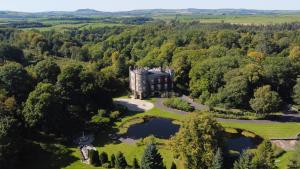 an aerial view of a castle in the forest at Cloncaird Castle Estate Cottages in Maybole