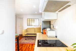 a kitchen and living room with a couch at GuestReady - Vibrant landscape in the 19th arr. in Paris