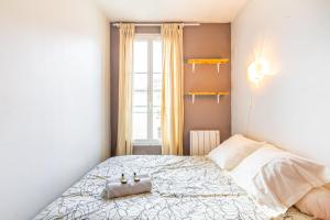 a small bedroom with a bed and a window at GuestReady - Vibrant landscape in the 19th arr. in Paris