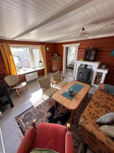 ein Wohnzimmer mit einem Tisch und einem Kamin in der Unterkunft Moskenes Cabin in Moskenes