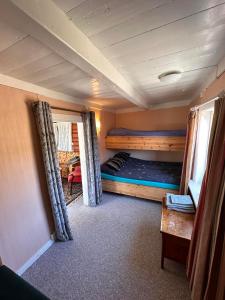 Zimmer mit 2 Etagenbetten und einem Tisch in der Unterkunft Moskenes Cabin in Moskenes