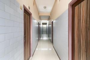 a corridor of a hallway with white walls and doors at OYO Jayanthi Mansion in Chennai