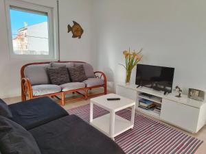 a living room with a couch and a tv at Casa da Ilha dos Ovos in Aveiro