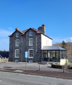 a large stone building with a bus stop in front of it at LLys Aeron Guest House in Aberaeron