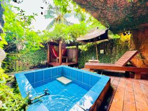 a plunge pool in a garden with a table and a bench at Kenting Afei Surf Hostel Nanwan in Nanwan