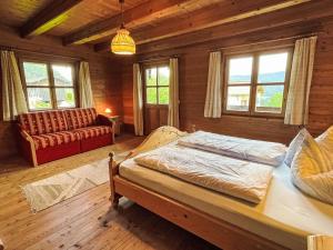a bedroom with a bed and a couch in a room at Holiday Home Marianne by Interhome in Reit im Winkl