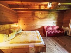 Un dormitorio con una cama y un sofá rojo. en Holiday Home Marianne by Interhome, en Reit im Winkl