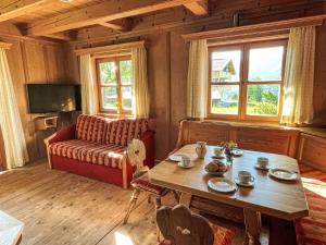 a living room with a table and a couch at Holiday Home Marianne by Interhome in Reit im Winkl