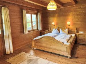 Un dormitorio con una cama en una cabaña de troncos en Holiday Home Marianne by Interhome, en Reit im Winkl