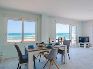 uma sala de jantar com mesa e cadeiras e o oceano em Apartment Talima-1 by Interhome em Denia