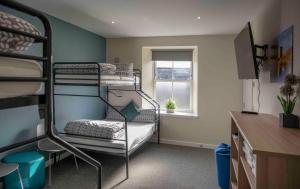 Pokój z 2 łóżkami piętrowymi i oknem w obiekcie Newcastleton Bunkhouse w mieście Newcastleton