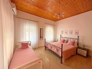 a bedroom with two beds and a wooden ceiling at Kalderimi View House in Dhërmi