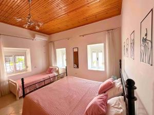 a bedroom with two beds and a wooden ceiling at Kalderimi View House in Dhërmi
