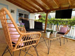 a patio with wicker chairs and a table and a television at Kalderimi View House in Dhërmi