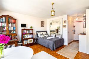 ein Wohnzimmer mit einem Bett und einem Bücherregal in der Unterkunft GuestReady - Flor de solstício de verão no 12º arr. in Paris