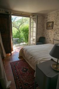 ein Schlafzimmer mit einem Bett und einem großen Fenster in der Unterkunft Mas de Bombequiols in Saint-André-de-Buèges